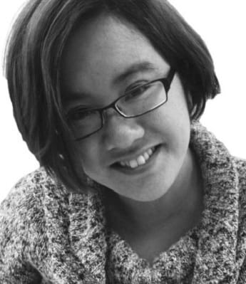 A black and white photo of Hoa Pham smiling at the camera.