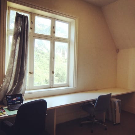 A photo of Studio 2 at Glenfern, with a long desk beneath a window with a laptop computer and chair