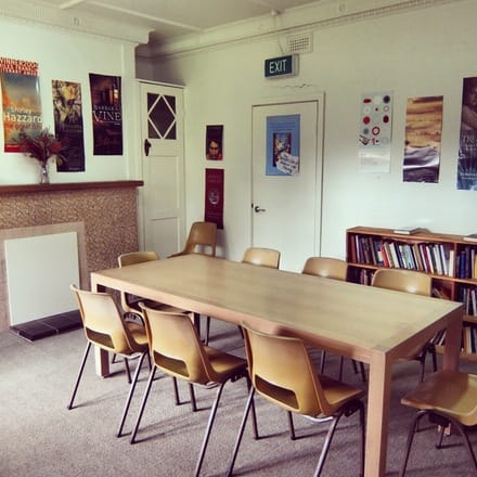 Photo of the Glenfern meeting room, featuring a large communal table in front of bookcases