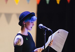 A photograph of a young person reading into a microphone